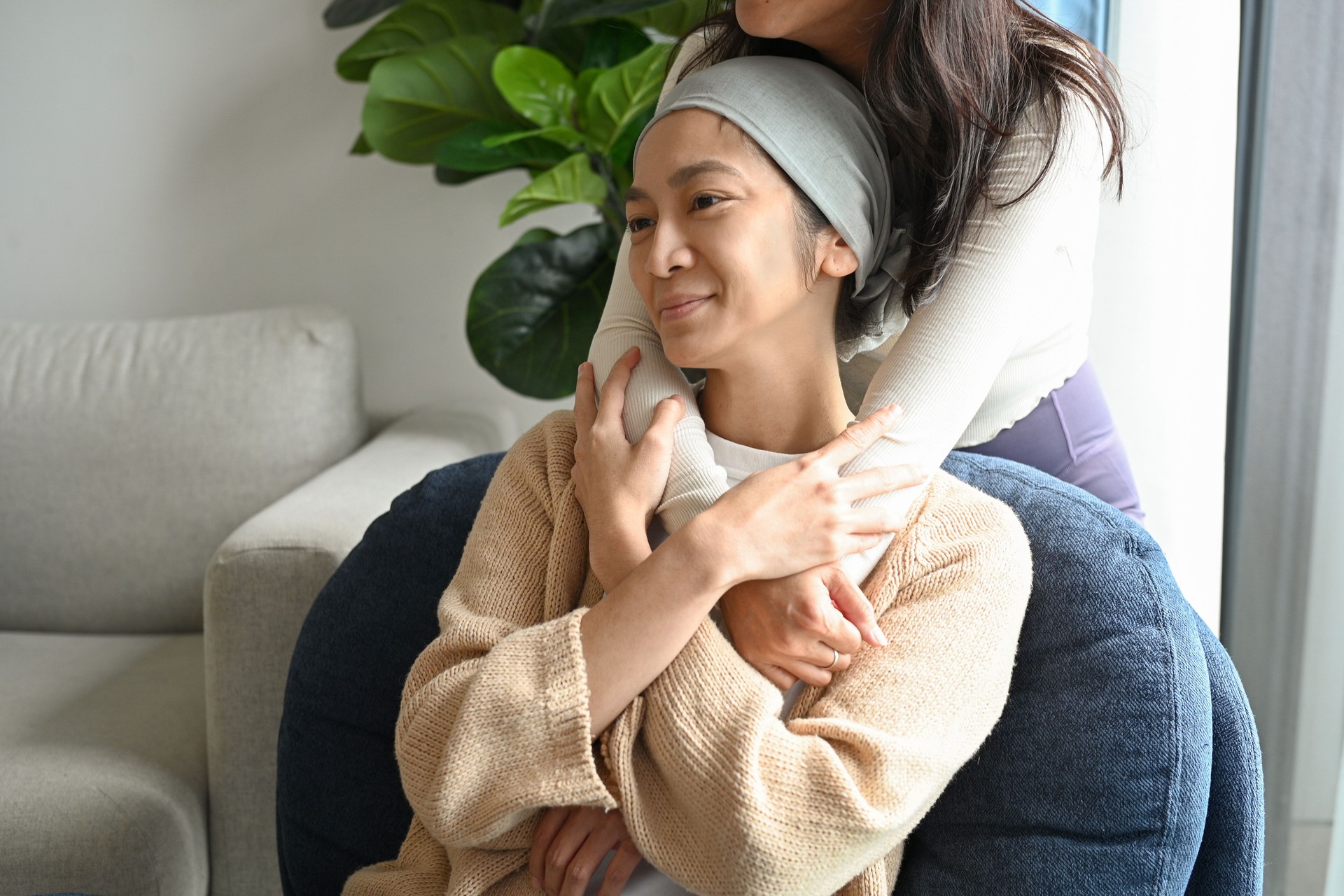 Asian woman embraces friend in sickness at home