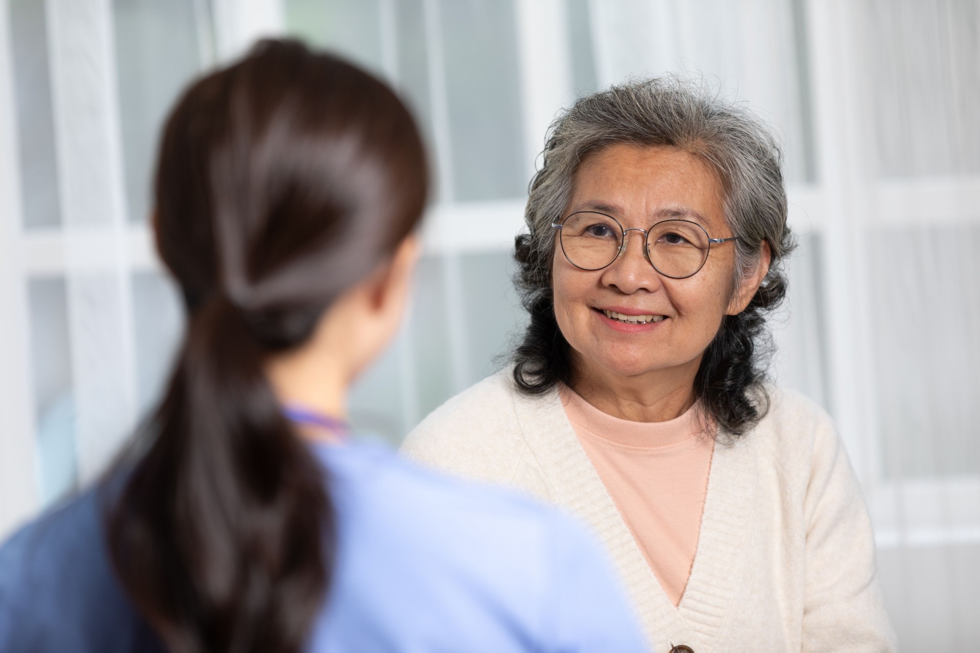 Senior or elderly patient looking at doctor smile and comfort.Happy elderly enjoy cheerful with doctor or nurse on couch.Health care premium service at home